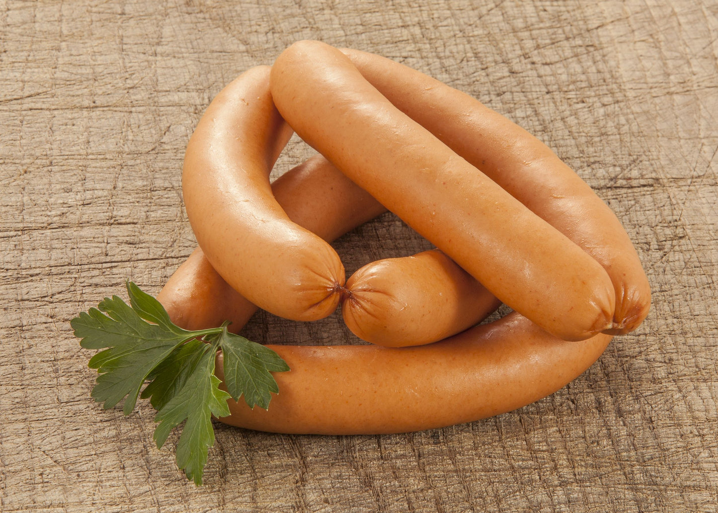 Würste mit Petersilie auf Holz.
