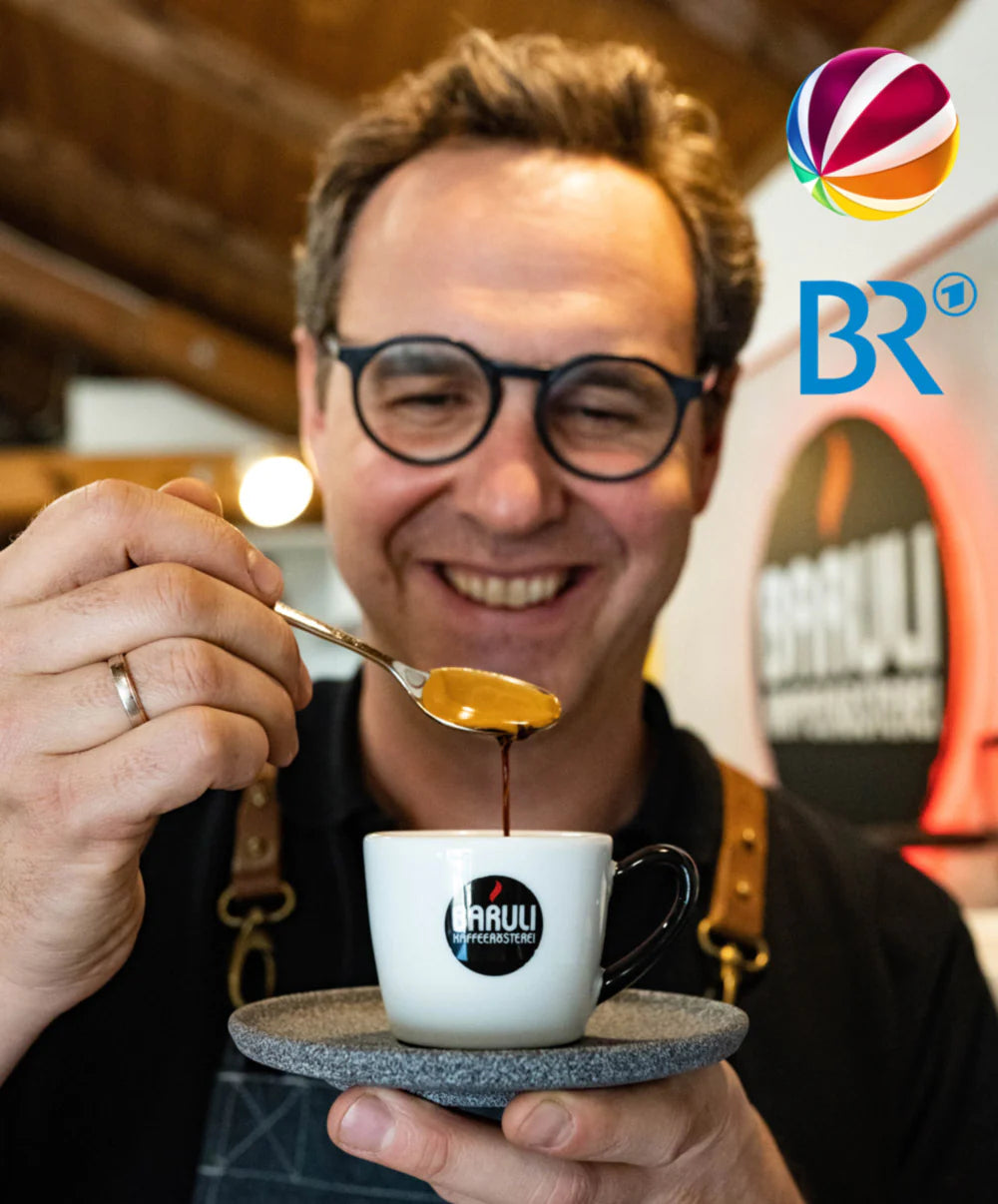 Mann mit Espresso und Löffel