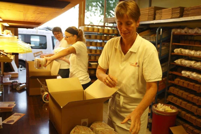 Personen packen Produkte in Kartons.