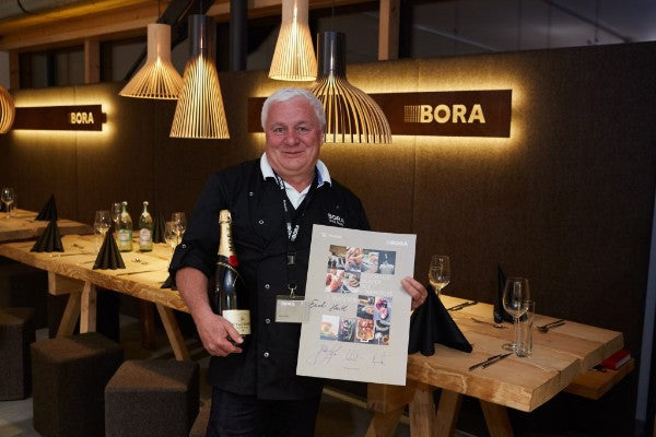 Mann hält Champagner und Poster