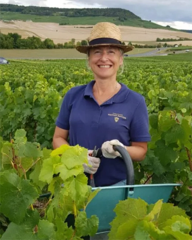 Frau in einem Weinberg lächelnd