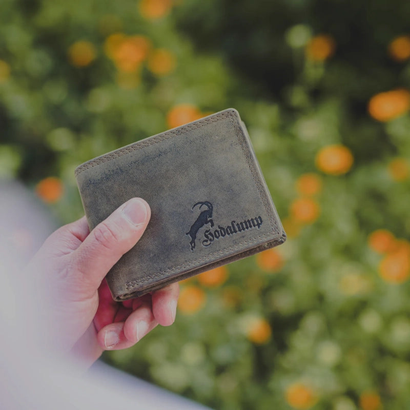 Hand hält Lederbrieftasche im Freien