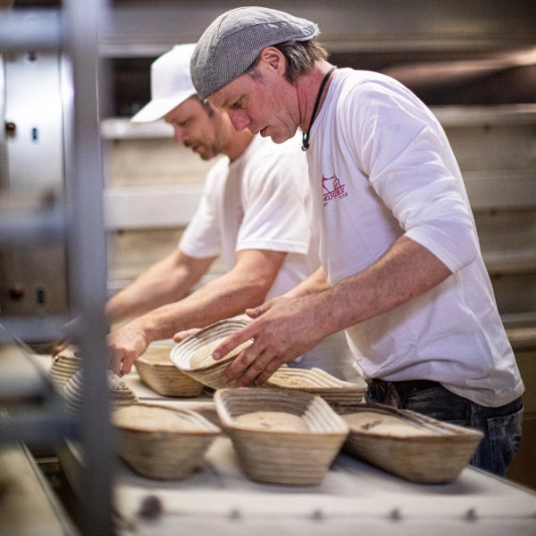 Bäcker formen Teig in Körben.